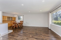Spacious room featuring wood-finish flooring, recessed lighting, and a large picture window - 