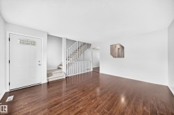Spacious living area featuring rich wood-finish flooring - 