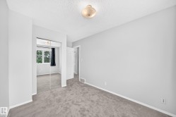 Carpeted interior space featuring light gray walls and white baseboards - 
