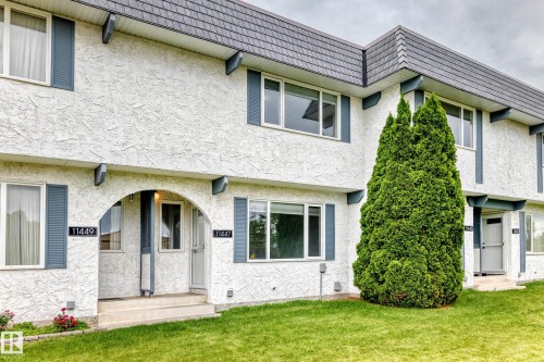 Stucco exterior with a peaked roofline and white window frames - 11447 22 Avenue Nw, Edmonton, AB 