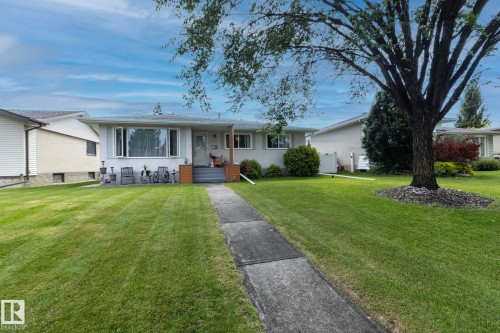Single-story residence featuring a bay window, concrete front walk, and a mature tree - 10623 75 Street Nw, Edmonton, AB 