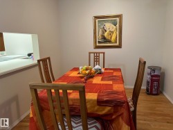 Dining area featuring wood-finish flooring and a pass-through window with white countertop - 