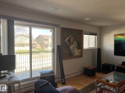Expansive sliding glass doors open to an outdoor balcony with metal railings - 