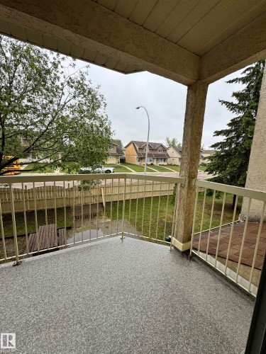 Exterior balcony featuring textured stucco walls, a durable speckled surface, and metal railings - 207 18012 95 Avenue, Edmonton, AB 