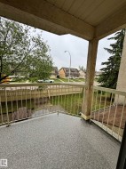 Exterior balcony featuring textured stucco walls, a durable speckled surface, and metal railings - 