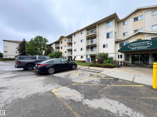 Multi-story building featuring a textured stucco exterior and a prominent front entrance with a green awning - 207 18012 95 Avenue, Edmonton, AB 
