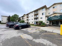Multi-story building featuring a textured stucco exterior and a prominent front entrance with a green awning - 