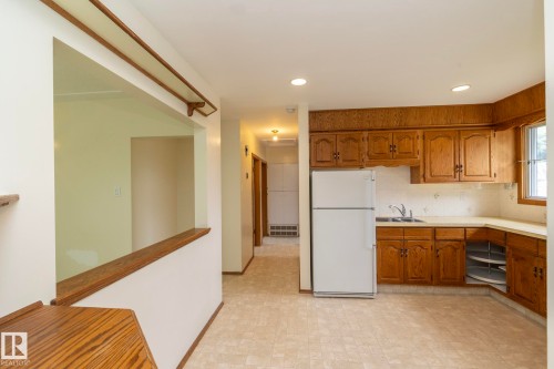 Kitchen featuring wood cabinetry, a corner sink, and recessed lighting - 5608 122 Avenue, Edmonton, AB 