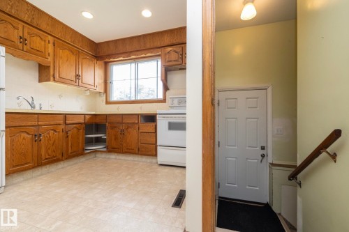 Kitchen featuring wood-finish cabinetry, recessed lighting, and a white appliance package - 5608 122 Avenue, Edmonton, AB 