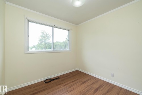 Room featuring wood-finish flooring, light-colored walls, and a ceiling-mounted light fixture - 5608 122 Avenue, Edmonton, AB 