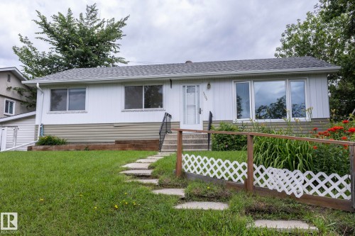 Ranch-style exterior with white vertical siding and tan horizontal foundation siding - 5608 122 Avenue, Edmonton, AB 