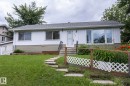 Ranch-style exterior with white vertical siding and tan horizontal foundation siding - 5608 122 Avenue, Edmonton, AB 