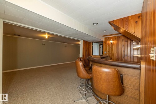 Finished basement space featuring a built-in bar with wood paneling - 5608 122 Avenue, Edmonton, AB 