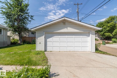 Detached single-car garage with white paneled door, horizontal siding, and concrete driveway - 5608 122 Avenue, Edmonton, AB 