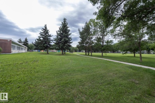 Expansive green space featuring a paved walkway and mature trees - 5608 122 Avenue, Edmonton, AB 