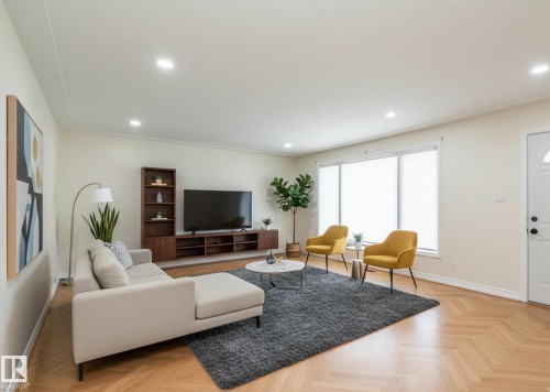 Spacious living area featuring herringbone wood-finish flooring, recessed lighting, expansive windows with roller shades, and a built-in media console with shelving - 5608 122 Avenue, Edmonton, AB 