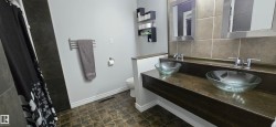 Dual vessel sinks with chrome faucets set into a floating dark wood vanity - 