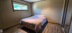 Bedroom with wood-finish flooring, neutral wall tones, and contrasting trim - 
