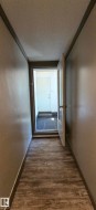 Entryway featuring wood-finish flooring, light-toned wall paint, and a white interior door - 