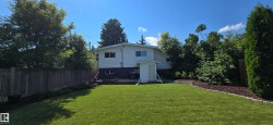Expansive green lawn with a white exterior home featuring a concrete patio - 