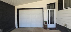 Integrated single-car garage featuring a white paneled door - 