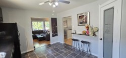 Kitchen area featuring square tile flooring, a frosted glass pantry door, and a built-in breakfast bar - 