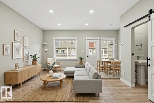 Open-concept living area featuring wood-finish flooring, recessed lighting, and a neutral color palette - 36 150 Everitt Dr, St. Albert, AB - Indoor Photo Showing Living Room