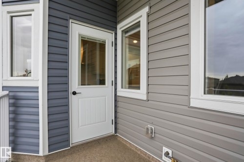 Exterior entry with a white paneled door featuring an upper window, black hardware, and white trim - 36 150 Everitt Dr, St. Albert, AB - Outdoor With Exterior