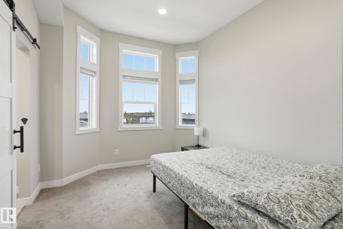 Room featuring a bay window with multiple vertical windows, light gray walls, recessed lighting, and gray carpet - 36 150 Everitt Dr, St. Albert, AB - Indoor Photo Showing Bedroom
