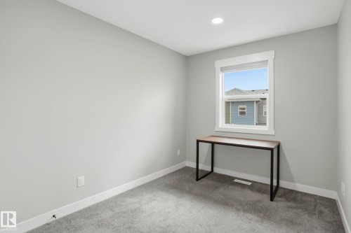 Neutral-toned room featuring a single window with white trim, recessed lighting, light gray walls, and gray carpeting - 36 150 Everitt Dr, St. Albert, AB - Indoor Photo Showing Other Room