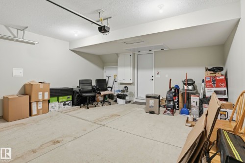 Spacious garage featuring a light gray painted interior, concrete flooring, overhead lighting, and an automatic garage door opener system - 36 150 Everitt Dr, St. Albert, AB - Indoor
