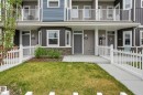 Townhome exterior featuring white picket fencing, an individual grassy area, a concrete walkway, and a covered porch entry - 36 150 Everitt Dr, St. Albert, AB  - Outdoor With Balcony With Facade 