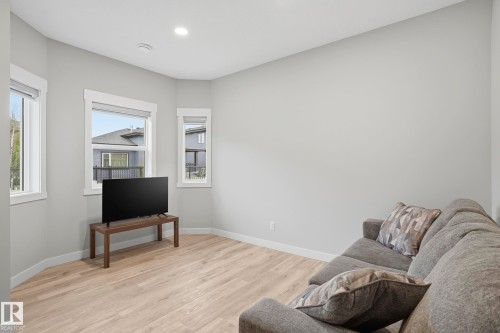 Room featuring multiple windows, recessed ceiling lighting, light gray wall paint, and wood-finish flooring - 36 150 Everitt Dr, St. Albert, AB - Indoor