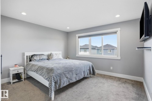 Bedroom featuring neutral gray walls, recessed lighting, a large white-framed window, and gray carpet flooring - 14 Copperhaven Drive, Spruce Grove, AB 