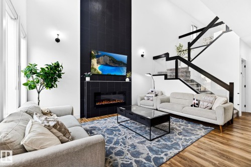 Double-height ceilings complement the black tiled fireplace with an electric insert - 423 42 Street, Edmonton, AB 