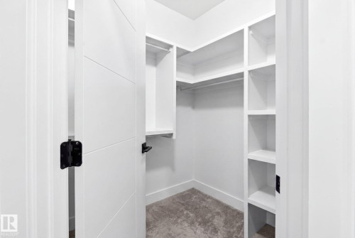 Walk-in closet with built-in shelving, hanging rods, and light-toned carpeting - 423 42 Street, Edmonton, AB 