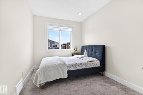 Carpeted room with a large window, neutral wall paint, white trim, and a recessed ceiling light - 423 42 Street, Edmonton, AB 