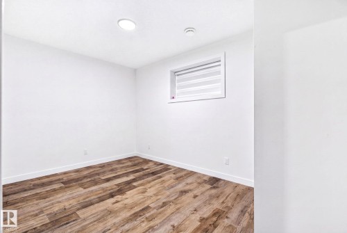 Room featuring wood-finish flooring, white walls, and a recessed ceiling light - 423 42 Street, Edmonton, AB 