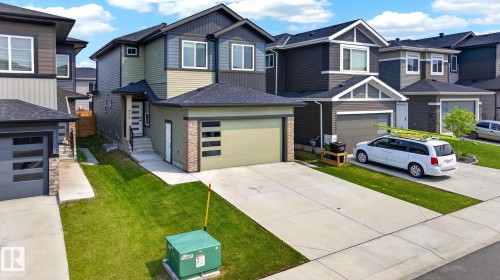 Contemporary two-story residence featuring multi-tone siding, a paved driveway, and an attached single-car garage with a modern glass-panel door - 423 42 Street, Edmonton, AB 