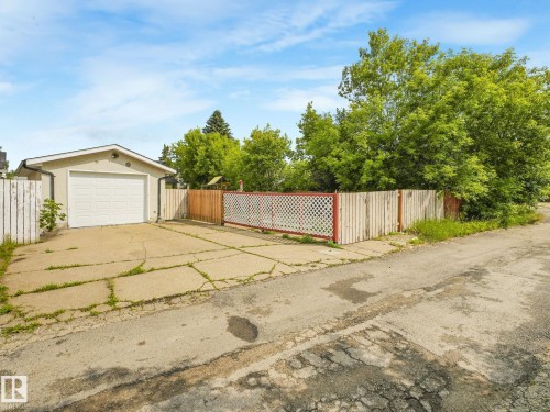 Detached garage featuring an overhead door and a stucco exterior finish - 9315 151 Avenue, Edmonton, AB 
