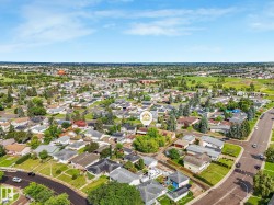 Aerial perspective showcasing a residential neighborhood with a mix of single-family homes and mature landscaping - 