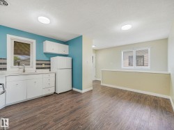 Kitchen area featuring white cabinetry, a single basin sink, and a white refrigerator - 