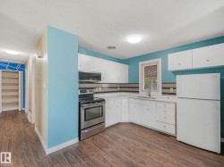 Kitchen featuring wood-finish flooring and white cabinetry - 