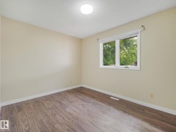 Interior room with wood-finish flooring, light neutral walls, and white trim - 