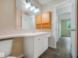 Bathroom vanity with a white basin sink, chrome faucet, and ample countertop space - 