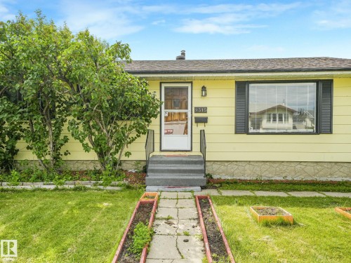 Exterior facade featuring yellow siding and black window shutters - 9315 151 Avenue, Edmonton, AB 
