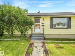 Exterior facade featuring yellow siding and black window shutters - 