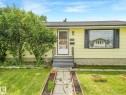 Exterior facade featuring yellow siding and black window shutters - 9315 151 Avenue, Edmonton, AB 