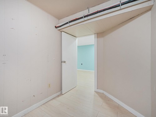 Interior space featuring light wood-finish flooring and a white paneled wall - 9315 151 Avenue, Edmonton, AB 