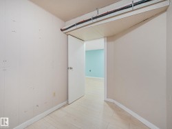 Interior space featuring light wood-finish flooring and a white paneled wall - 